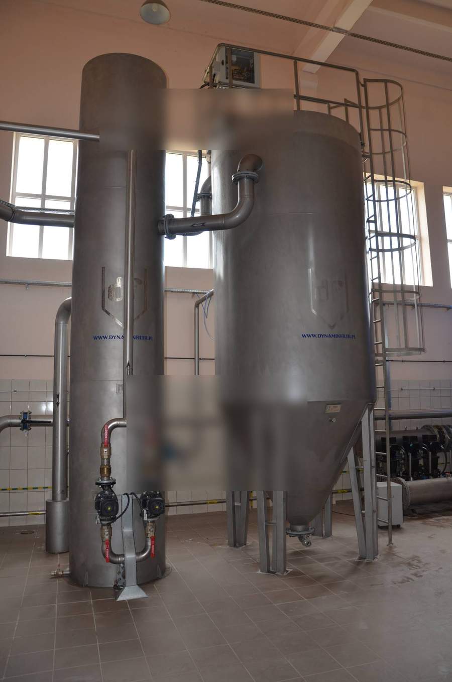 Stainless steel conical bottom filter vessel alongside a horizontal buffer contact tank with automated valve manifold