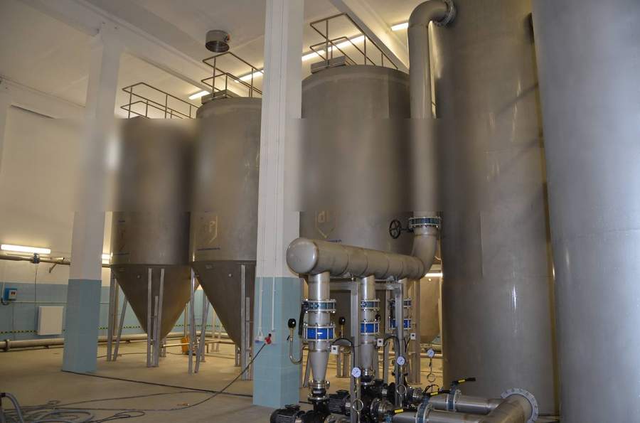 Multiple stainless steel conical-bottom pressure filters with shared manifold header, automated valves and pressure gauges